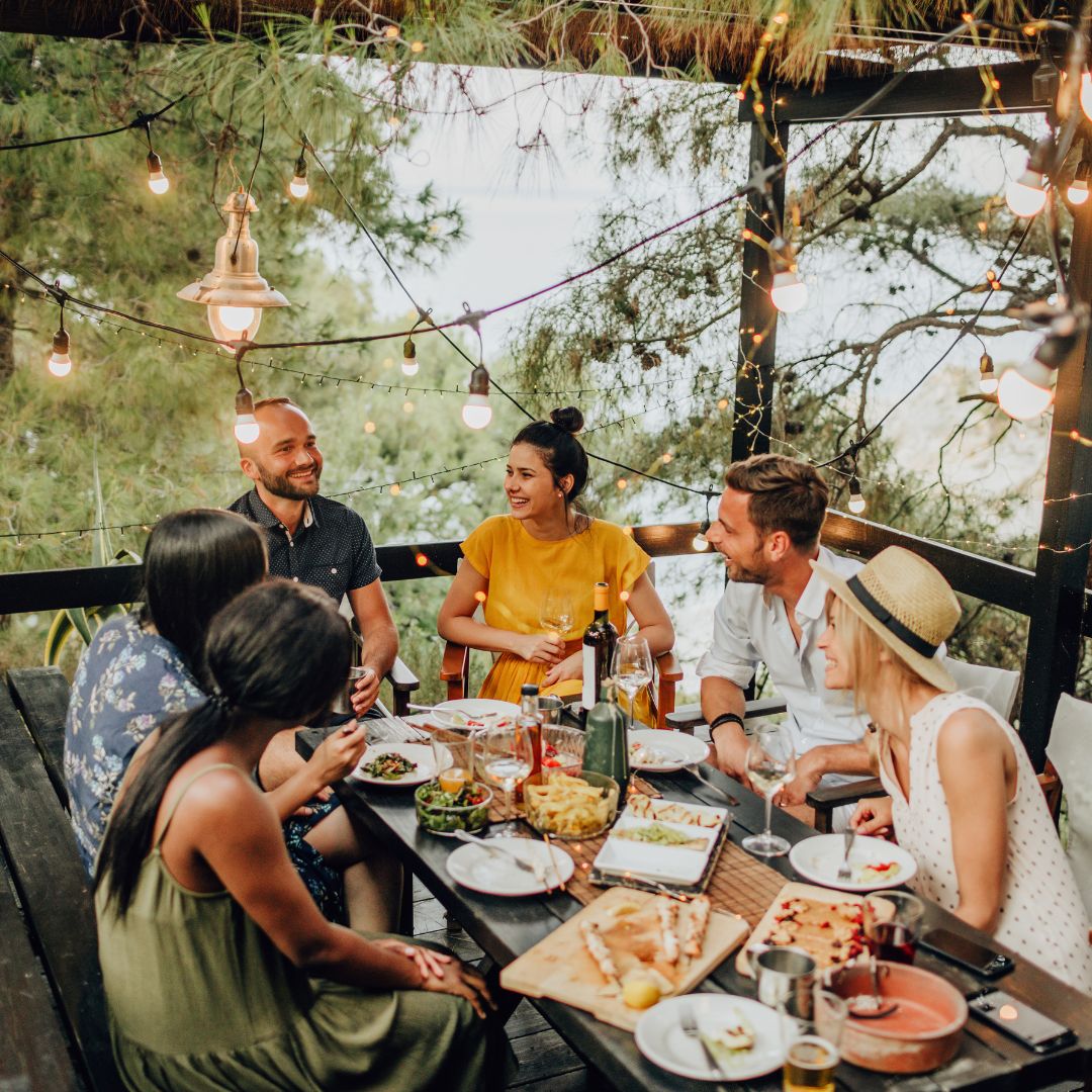 Friends having dinner under a motorized pergola